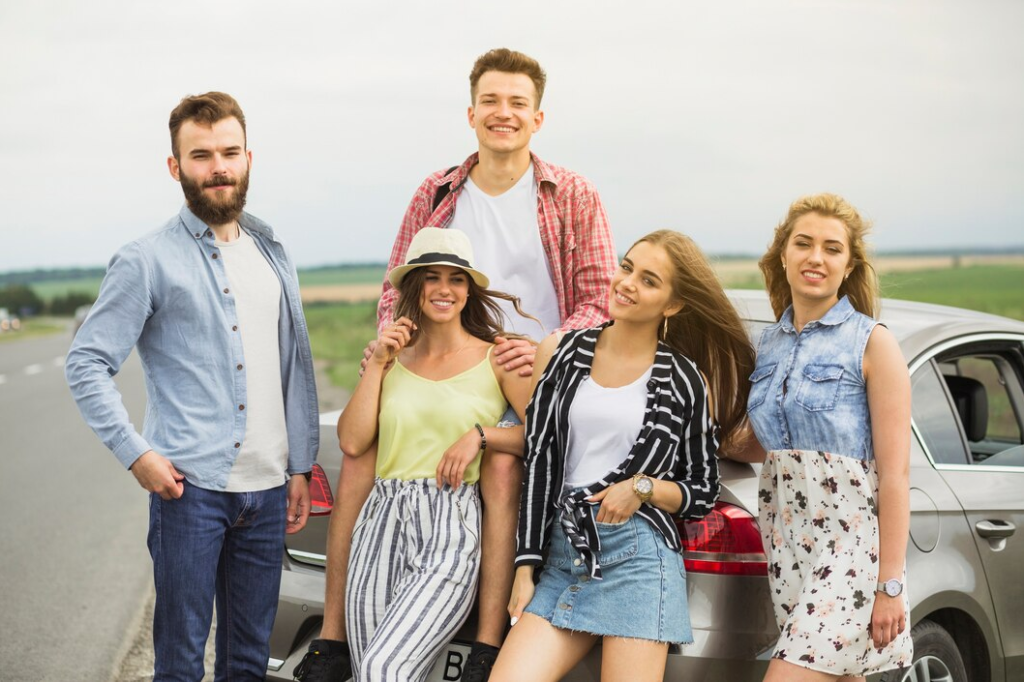 portrait smiling young friends standing near car